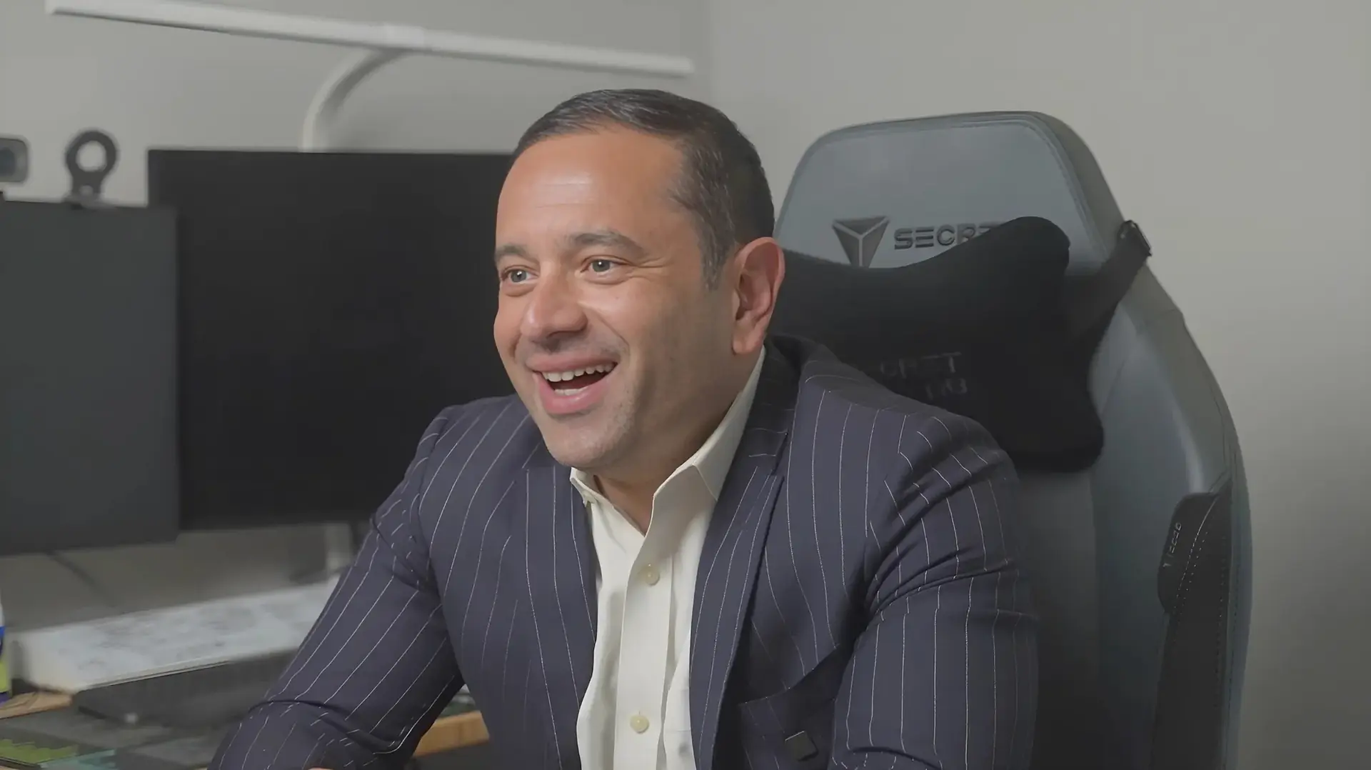 Nik Agharkar smiling at his desk