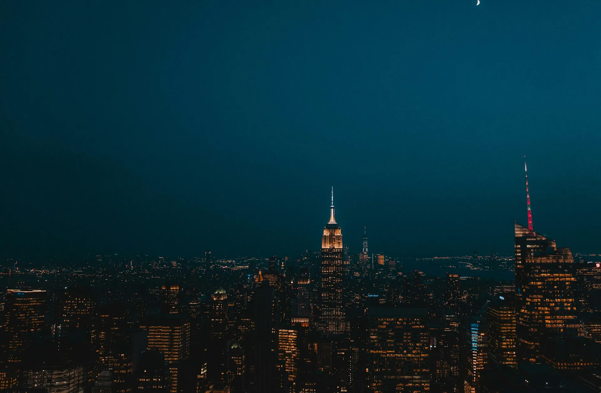 The Manhattan skyline at night with the Empire State Building lit up
